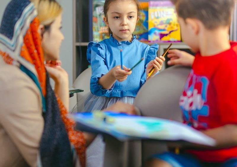 Children learning with a teacher in a classroom.
